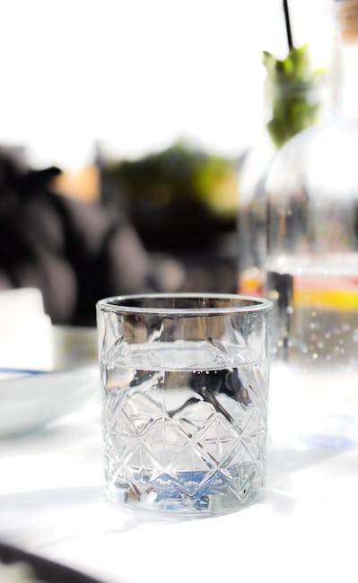 Ant stalo stovinti vandens stiklinė ir užrašų popierius ryte, primenantis mažą įpročio startą