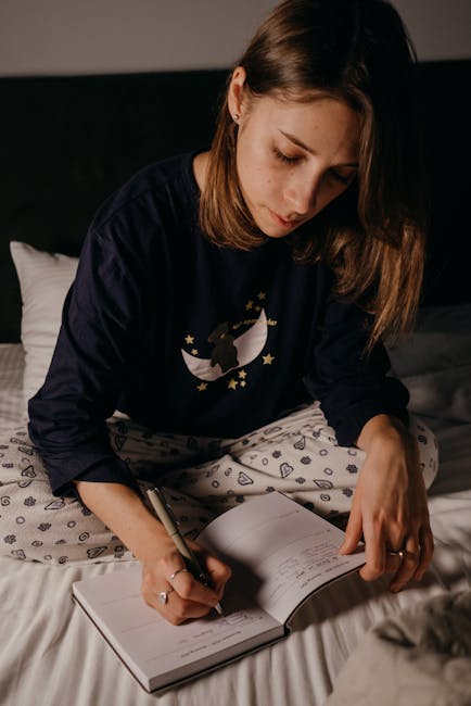 Asmuo prie stalo rašo užrašus prieš miegą, padeda nuraminti protą ir mintis