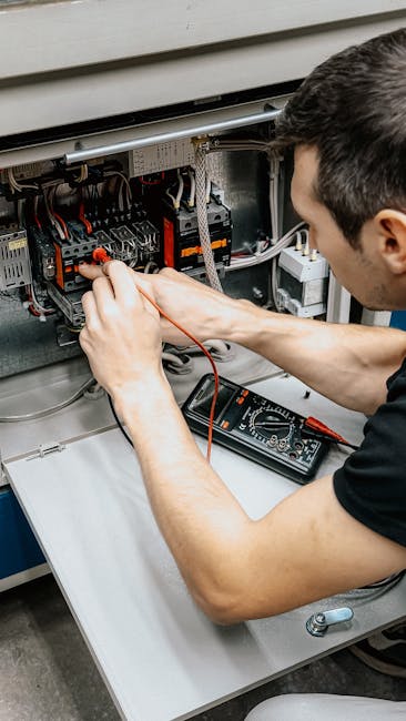 Meistras su apsauginėmis priemonėmis dirba elektros skydelyje