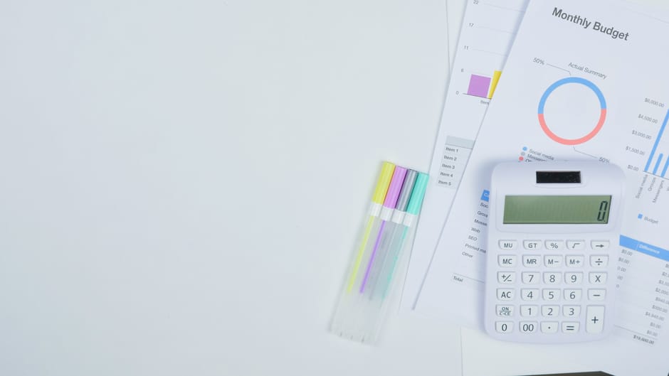 Asmuo prie stalo skaičiuoja išlaidas ir planuoja namų automatizavimo pirkinius