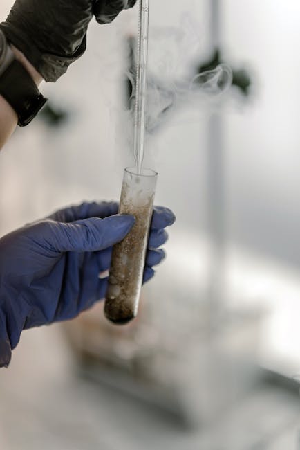 Ant lubų įrengtas dūmų detektorius, žmogus paspaudžia testavimo mygtuką